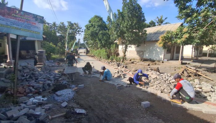 Satgas TMMD 125 Lanjutkan Pengerjaan Paving Jalan Menuju Jembatan di Siliragung